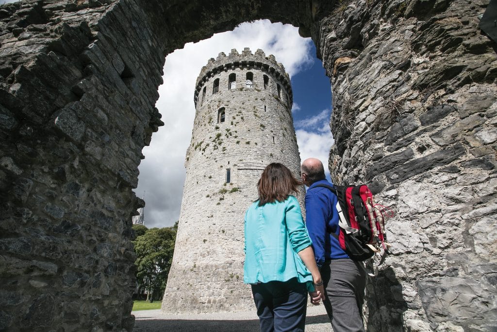 A couple holding hands looking up at Nenagh Castle