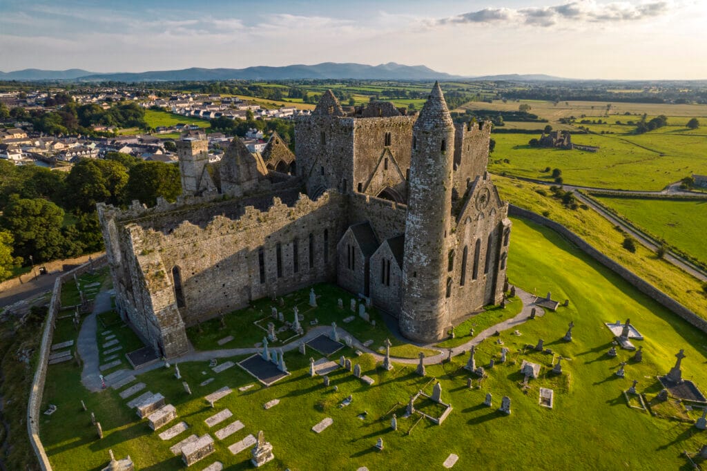 Aerial view of the Rock of Cashel with the Galtee Mountains in the distance, highlighting one of the world’s top destinations in Ireland